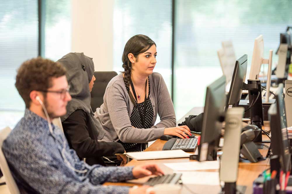 3 people working in front of computers